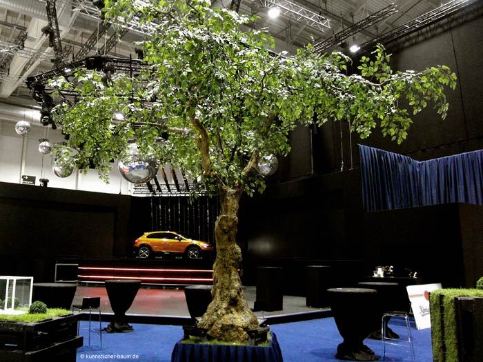 Großer, belaubter Kunstbaum mit knorrigem Stamm als TV-Event Dekoration
