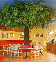 Ein dicht belaubter Kunstbaum in der Gastronomie 